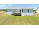 Back exterior view of house with deck and large backyard lawn on a sunny day at 357 Sherrill Farm Dr, Benson, NC 27504