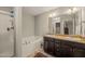 Bright bathroom boasts double sink vanity, bathtub, and glass-enclosed shower at 357 Sherrill Farm Dr, Benson, NC 27504