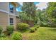 View of the backyard of a home with stone retaining wall, lush green lawn, and mature trees at 37 Wedgewood Rd, Chapel Hill, NC 27514