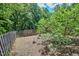 Landscaped yard with mature trees, enclosed by a wooden fence at 37 Wedgewood Rd, Chapel Hill, NC 27514