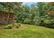 Backyard landscape featuring mature trees and natural stone retaining wall at 37 Wedgewood Rd, Chapel Hill, NC 27514
