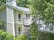Two-story home featuring a stone retaining wall and second floor porch nestled among mature trees at 37 Wedgewood Rd, Chapel Hill, NC 27514