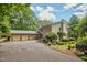 Charming home boasts stone accents, mature trees, and a three-car garage for ample parking at 37 Wedgewood Rd, Chapel Hill, NC 27514