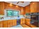 Traditional kitchen with wood cabinetry, stainless steel appliances, and a window overlooking the backyard at 37 Wedgewood Rd, Chapel Hill, NC 27514