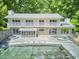 Expansive home featuring a large pool, stone patio, multiple balconies, and beautiful wooded surroundings at 37 Wedgewood Rd, Chapel Hill, NC 27514