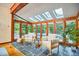Bright sunroom featuring wood beams, stone floors, and multiple windows offering scenic outdoor views at 37 Wedgewood Rd, Chapel Hill, NC 27514