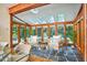 Bright sunroom featuring wood beams, stone floors, and multiple windows offering scenic outdoor views at 37 Wedgewood Rd, Chapel Hill, NC 27514