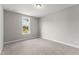 This bedroom features neutral carpet, gray walls, base molding, and a bright window at 40 W Victoria Ridge Dr # 18, Selma, NC 27576