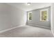 This bedroom features neutral carpet, gray walls, base molding, and bright windows at 40 W Victoria Ridge Dr # 18, Selma, NC 27576
