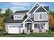 Inviting home showcasing stone accents, a two-car garage, and manicured lawn under a bright blue sky at 40 W Victoria Ridge Dr # 18, Selma, NC 27576