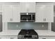 Contemporary kitchen features stainless steel appliances, herringbone backsplash, and custom cabinetry at 40 W Victoria Ridge Dr # 18, Selma, NC 27576