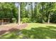 Expansive backyard with lush lawn, mature trees, and a wood shed, offering a serene outdoor space at 421 Ridgefield Rd Rd, Chapel Hill, NC 27517