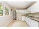 Functional kitchen space with white cabinets, a window, and access to the back deck at 421 Ridgefield Rd Rd, Chapel Hill, NC 27517