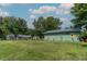 Expansive backyard view highlighting a storage shed with sunflower artwork, a detached garage, and a well-maintained lawn at 444 Barnette Rd, Louisburg, NC 27549