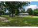 The wide, grassy backyard presents a peaceful setting with a distant view of the house, pool, and garden structures at 444 Barnette Rd, Louisburg, NC 27549