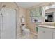 A bright bathroom features a glass shower, white toilet, granite vanity, and beige walls at 444 Barnette Rd, Louisburg, NC 27549