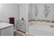 Elegant bathroom with gray vanity, tub, silver accents and bright patterned wallpaper at 444 Barnette Rd, Louisburg, NC 27549