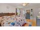 Bright bedroom featuring a colorful quilt, wood headboard, and light-toned wood flooring at 444 Barnette Rd, Louisburg, NC 27549