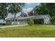 Ranch home with a covered porch, American flag, mature trees, and a circular driveway at 444 Barnette Rd, Louisburg, NC 27549