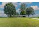 Ranch style home with a covered porch surrounded by mature trees and an American flag at 444 Barnette Rd, Louisburg, NC 27549