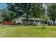 Charming brick ranch with a white picket fence, covered porch, mature trees, and attached carport at 444 Barnette Rd, Louisburg, NC 27549