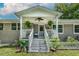 Charming covered porch with a ceiling fan, seating area, and decorative plants at 444 Barnette Rd, Louisburg, NC 27549