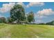 Serene front yard view featuring a charming home set back from the road on a spacious lot with mature trees and a gentle slope at 444 Barnette Rd, Louisburg, NC 27549