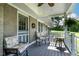 Relaxing covered porch with comfortable seating and a view of the lush, green landscape at 444 Barnette Rd, Louisburg, NC 27549