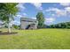 A spacious backyard showcasing a well-maintained lawn, mature trees, and a charming home exterior at 45 Leighann S Ct, Timberlake, NC 27583