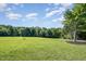 Expansive backyard featuring lush green grass and mature trees on a sunny day at 45 Leighann S Ct, Timberlake, NC 27583