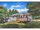 Charming home featuring a wooden deck, fenced yard, and mature trees providing shade and privacy at 4533 Whistling Way, Raleigh, NC 27616