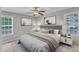 Nicely staged bedroom featuring two windows, a ceiling fan, and matching decor at 4533 Whistling Way, Raleigh, NC 27616