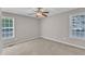 Bedroom featuring carpet, two windows, and a ceiling fan with light at 4533 Whistling Way, Raleigh, NC 27616