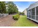 View of the backyard featuring a retaining wall, bushes, grass and the side of the house at 4562 Brighton Ridge Dr, Apex, NC 27539