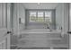 Bathroom with a stand alone tub set on a tile platform and a large window at 4562 Brighton Ridge Dr, Apex, NC 27539