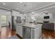 Open concept kitchen with stainless appliances, white cabinets, large island, and open view to the living area at 4562 Brighton Ridge Dr, Apex, NC 27539