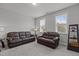 Living room featuring two leather sofas, carpet flooring, and natural light from large windows at 4562 Brighton Ridge Dr, Apex, NC 27539