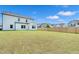 Expansive backyard with lush green grass, privacy fence, and view of the home's exterior at 4601 Okeechobee Ct, Fuquay Varina, NC 27526
