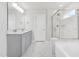 Bright bathroom with double sink vanity, soaking tub, glass shower with marble tile, and linen closet at 4601 Okeechobee Ct, Fuquay Varina, NC 27526