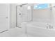 Clean bathroom featuring tiled floor, a soaking tub, and a separate glass shower with marble tile at 4601 Okeechobee Ct, Fuquay Varina, NC 27526