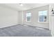 Bedroom featuring gray carpet, two large windows, and neutral paint at 4601 Okeechobee Ct, Fuquay Varina, NC 27526