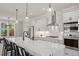 Modern kitchen with stainless steel appliances, white cabinets, stone counters, and stylish lighting at 509 Sherron Rd # 11, Durham, NC 27703
