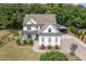 Stunning aerial view of this two-story white farmhouse-style home showcasing lush landscaping at 5180 Old Powell Rd, Holly Springs, NC 27540