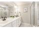 Modern bathroom featuring a double vanity, elegant mirrors, and a glass-enclosed shower at 5180 Old Powell Rd, Holly Springs, NC 27540