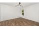 Bright, minimalist bedroom featuring hardwood floors, white walls, and a ceiling fan at 5180 Old Powell Rd, Holly Springs, NC 27540