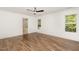 Spacious bedroom featuring hardwood floors, white walls, a ceiling fan, and a bathroom at 5180 Old Powell Rd, Holly Springs, NC 27540