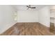 Bright bedroom with hardwood floors, white walls and trim, ceiling fan, and a closet at 5180 Old Powell Rd, Holly Springs, NC 27540