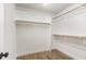Walk-in closet with laminate floors and built-in shelving and clothing rods at 5180 Old Powell Rd, Holly Springs, NC 27540