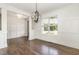 Elegant dining room featuring dark wood floors, classic wall paneling, and a modern light fixture at 5180 Old Powell Rd, Holly Springs, NC 27540