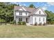 Charming two-story white farmhouse-style home with well-maintained lawn and landscaping creating a welcoming curb appeal at 5180 Old Powell Rd, Holly Springs, NC 27540